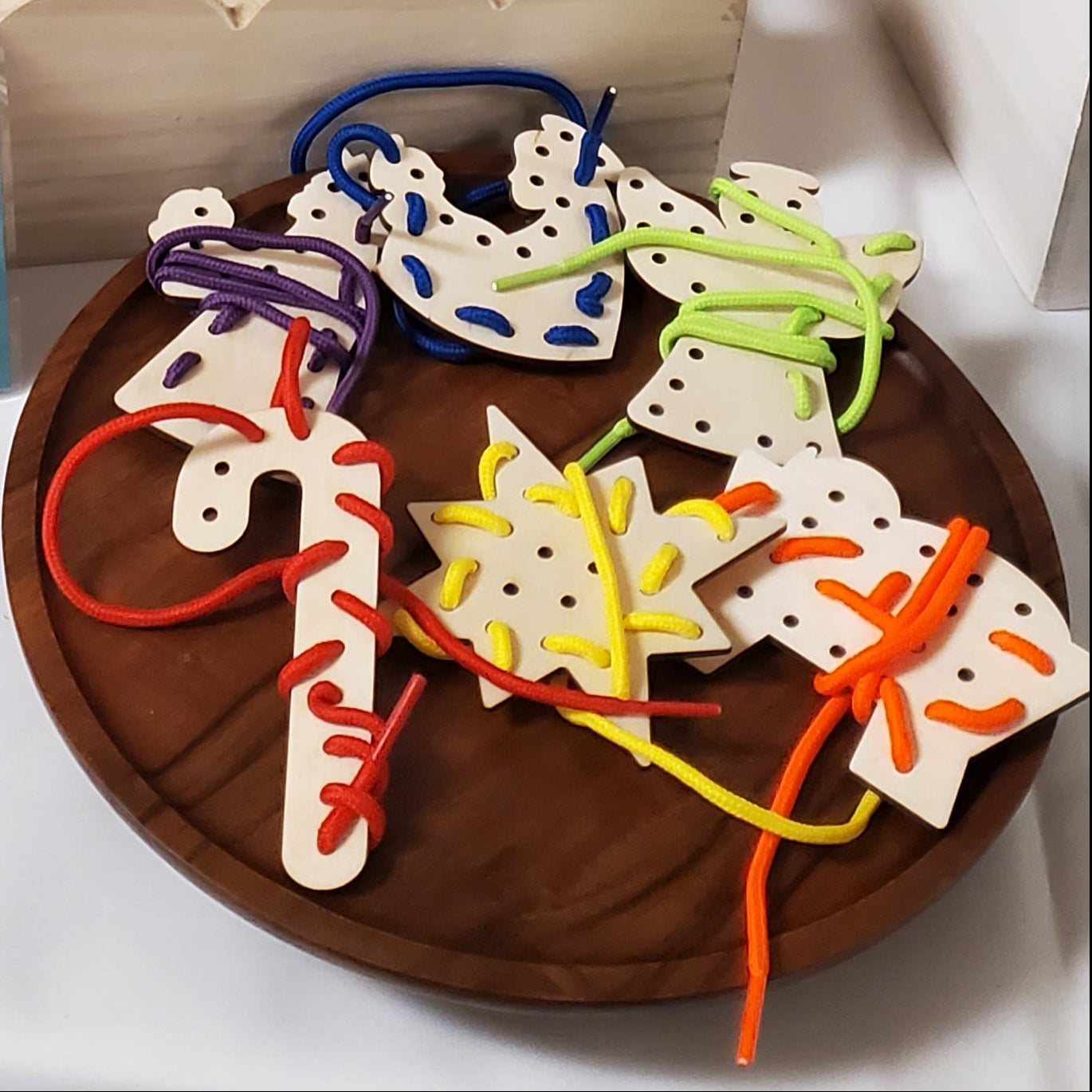 Christmas lacing cards on a wooden riser